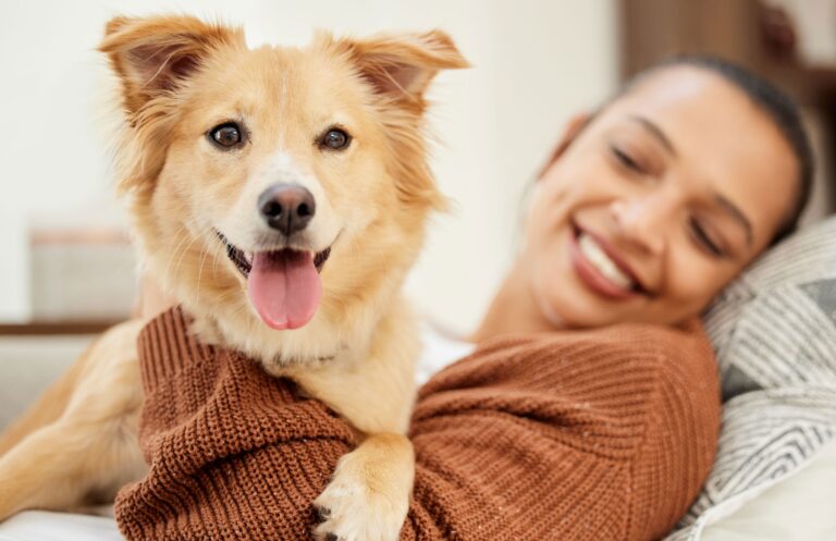 Woman holding mixed breed dog. The best dog dna test kits can help you determine your dog's breed makeup and more.